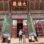 Tourists standing before a temple entrance in vibrant Seoul colors.