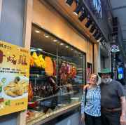 Visitors enjoying a moment outside a vibrant Hong Kong eatery display.