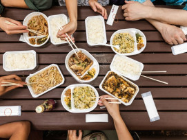 Various Japanese dishes with people sitting around the Various Japanese dishes with people sitting around the