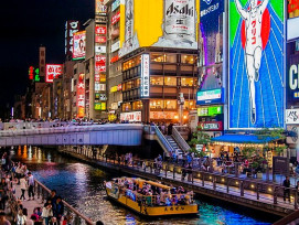 Crowds gathered on Ebisubashi Bridge at night with the Glico sign visible in the background. Photo by Type specimen on Creative Commons Attribution-Share Alike 3.0. Crowds gathered on Ebisubashi Bridge at night with the Glico sign visible in the background. Photo by Type specimen on Creative Commons Attribution-Share Alike 3.0.