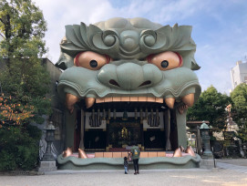 The distinctive lion head structure at Namba Yasaka Shrine against modern buildings The distinctive lion head structure at Namba Yasaka Shrine against modern buildings
