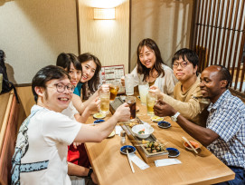 Intimate izakaya scene with host introducing dishes Intimate izakaya scene with host introducing dishes