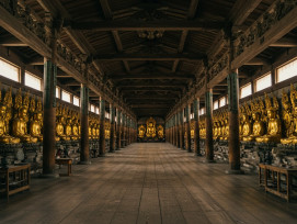 Interior view of Sanjusangen-do showing rows of golden Buddha statues receding into the distance