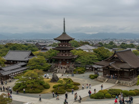 A panoramic view showing multiple temple complexes across Kyoto with visitors exploring different architectural styles A panoramic view showing multiple temple complexes across Kyoto with visitors exploring different architectural styles