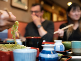 Tourists enjoying Japanese food. Tourists enjoying Japanese food.
