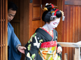 Geisha walking out of a traditional wooden structure