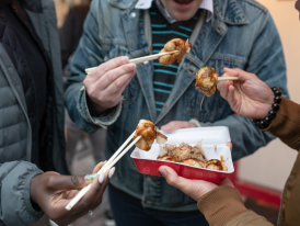 People eating street food with chopsticks