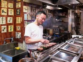 Person cooking Japanese food in a local Izakaya
