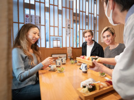Travelers about to enjoy sushi with a local host in Tok