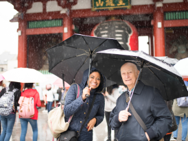 Locals taking shelter under covered shopping arcades during a rainy season downpour