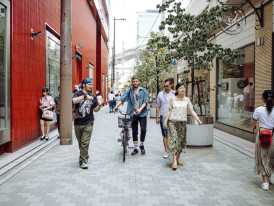 Cyclist passing street mural in hip Osaka neighborhood.
