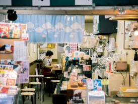 Traditional shopkeeper arranging goods in covered arcade. Image by Satoshi Hirayama from pexels