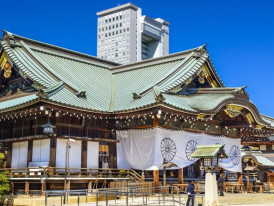 Traditional shrine architecture contrasting with modern buildings.