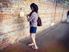 Visitor reading historical displays while others rush past. Image by mali maeder from pexels