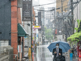 Local businessman with umbrella navigating flooded Osaka sidewalk during heavy rain Photo by Hugo Sykes on pexels