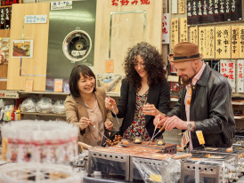 Small group gathered at street stall sampling food.