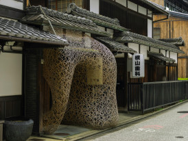 A tucked-away shrine between modern buildings. Image by Charlie Charoenwattana from Unsplash