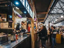 Various street food vendors in a bustling market setting.