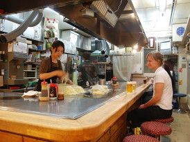 Guests trying okonomiyaki in a local kitchen. Image by Maarten Heerlien from Voorschoten, The Netherlands Creative Commons Attribution 2.0