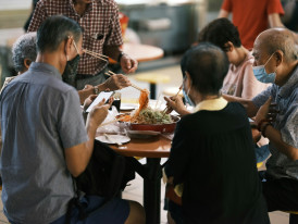 A multi-generational family sharing a meal at a casual restaurant near Osaka Station, with the local host helping facilitate conversation and ordering. Image by Galen Crout on Unsplash.