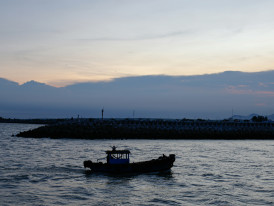 Osaka Bay at sunrise with fishing boats returning to harbor Photo by DIEU on Unsplash
