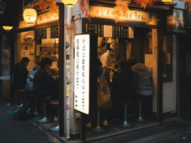 Small local restaurant with patrons enjoying evening meal. Photo by Willian Justen de Vasconcellos on Unsplash
