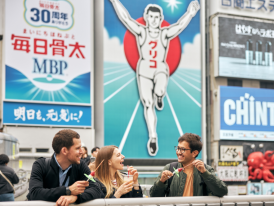 The famous Glico running man sign and other neon lights reflecting in Dotonbori canal
