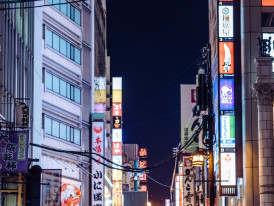 Street-level view of Dotonbori at night with crowds of people and restaurant signs