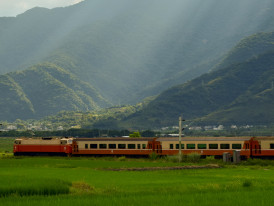 Traditional train traveling through Japanese countryside with mountains in background Photo by Tseng Shiya on Unsplash