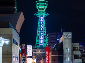 Tsutenkaku Tower lit up at night with surrounding Shinsekai district neon signs