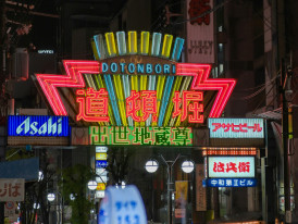 Entrance to Janjan Yokocho lit by colorful blinking neon signs at night. Image by Haoli Chen on Unsplash.