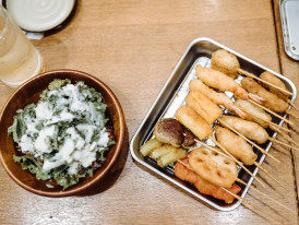 Golden, crispy kushikatsu skewers just fried and served on a metal tray, ready to eat.