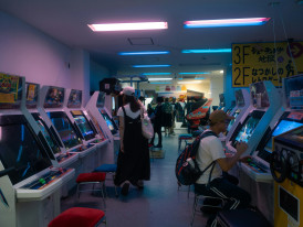 Rows of brightly lit arcade machines inside a Shinsekai gaming center. Image by Gaku Suyama on Unsplash.