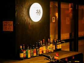 Dimly lit bar in Shinsekai with warm lighting and a few seats, creating an intimate atmosphere. Image by 5010 on Unsplash.