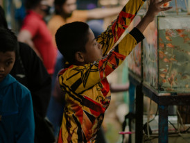 Kids trying to catch goldfish at a festival game stall Photo by shot ed on Unsplash