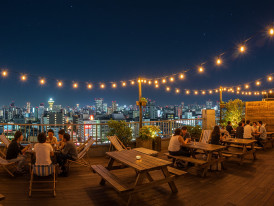 Rooftop beer garden with string lights and city views