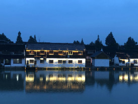 Traditional building reflected in pond at sunset Photo by CHENGKAI LOU on Unsplash