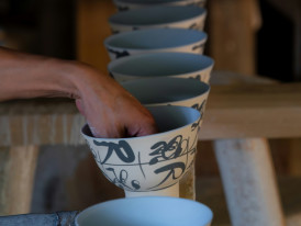 Master craftsperson demonstrating traditional pottery techniques to interested visitors. Photo by yi yan on Unsplash
