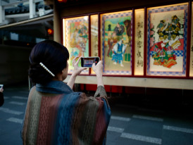 Traveler using smartphone while local host provides cultural context Photo by Kazuo ota on Unsplash