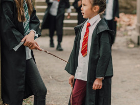 Wizarding World of Harry Potter with visitors in robes Photo by RDNE Stock project on pexels