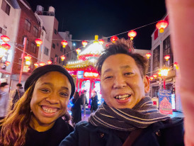 A guest and guide laughing while walking through a traditional neighborhood.