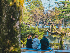 A guide and travelers engaged in a thoughtful conversation at a peaceful outdoor spot, seated or standing in a relaxed setting. Photo by Roméo A. on Unsplash