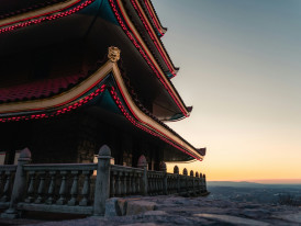 Golden hour light hitting snow-covered temple roofs with dramatic shadows across traditional architecture Photo by Andre Frueh on Unsplash