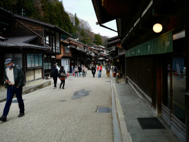 Stone-paved traditional street with wooden buildings and visitors in kimono walking leisurely Photo by Kazuo ota on Unsplash