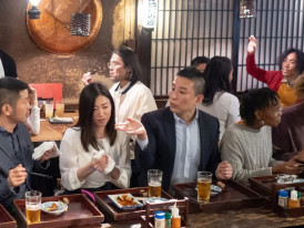 A guided walking tour group learning about Buddhist temple architecture while exploring Nishiki Market area