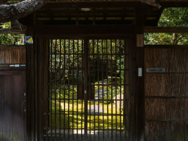 Traditional Japanese house with garden visible through wooden gates. Image by David Emrich from Unsplash