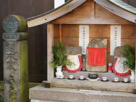 Small neighborhood shrine with fresh offerings and hand-written prayers. Image by zenigame photo from Unsplash