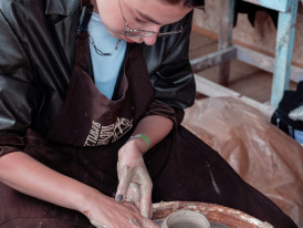 Traditional pottery workshop with artisan shaping clay on a wheel. Image by Vicky Hladynets from Unsplash