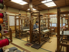 Traditional textile workshop with colorful silk threads and weaving equipment.