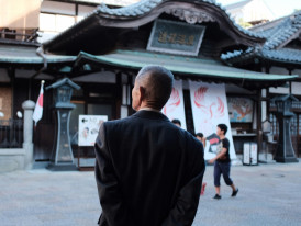 Traveler pausing to admire traditional architecture with a local host nearby Photo by Mak on Unsplash